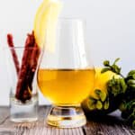Highball whiskey soda served in a whiskey glass with a wedge of lemon and beef sticks.