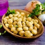 Hawaiian style onion garlic macadamia nuts served on a wooden plate.