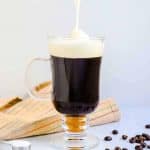 Sea salt foam being poured on top of coffee in a cup.