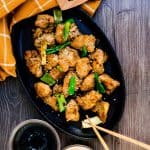 Korean BBQ marinated chicken severed on a cast iron pan topped with sesame seeds, top down shot.