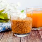 Chia seed pudding made with tea ice tea served in a glass topped with whipping cream and fresh mint.