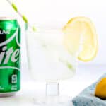 Homemade Sprite served in a glass with lemon slice top with a straw next to a can of Sprite.