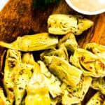 Air fried artichoke hearts served on a wooden plank.