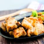 Miso pork belly served on a cast iron plate next to kimchi.