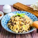Japanese style beef fried rice served in a bowl with a wooden spoon.