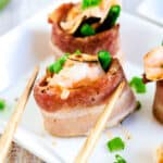 Shrimp bacon rolls topped with spicy mayo sauce and chopped green onions.