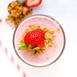 Strawberry cheesecake smoothie served in a glass cup, top down view.