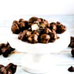 Chocolate covered macadamia nuts dessert snack served on a dessert pedestal.