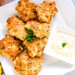 Shrimp cakes served on a plate with garlic lemon aioli sauce showing cross sectional cut, top down shoaShrimp cakes served on a plate with garlic lemon aioli sauce, top down shot.t.