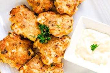 Shrimp cakes served on a plate with garlic lemon aioli sauce showing cross sectional cut, top down shoaShrimp cakes served on a plate with garlic lemon aioli sauce, top down shot.t.