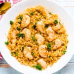 Garlic shrimp cauliflower fried rice served in a white bowl topped with fresh parsley, top down shot.
