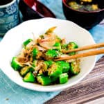 Japanese okra salad topped with katsuoboshi bonito flakes being picked up with a pair of chopsticks.