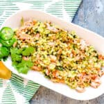 Chili lime salmon cauliflower fried rice served on a plate with a golden spoon.