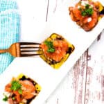 Cold smoked salmon carpaccio appetizer served on a white plate topped with a olive oil vinaigrette dressing.