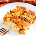Bacon cheddar cauliflower gratin served on a white plate with fork.