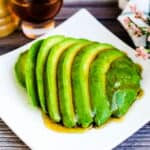 Sliced avocado with a olive oil soy sauce based dressing poured on.