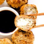 Cream cheese dumplings made with an air fryer showing a cross sectional cut being picked up with a pair of chopsticks.