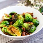 Brussels sprout stir fry served in a white bowl.