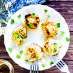 Pan butter seared scallops served with a drizzle of spicy mayo and radish sprouts, top down shot.