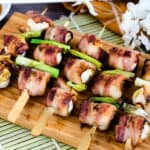 Bacon wrapped quail eggs yakitori grilled on the BBQ served on a wooden plank.
