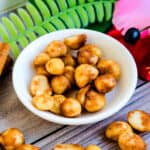 Cinnamon sugar glazed macadamia nuts served in a white bowl.