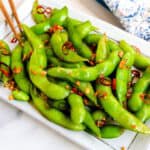 Garlic truffle edamame served on a white plate.
