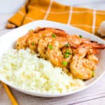 Honey garlic marinated shrimp served over a bed of rice topped with chili pepper and scallions.