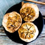 Japanese style oven roasted garlic served on a cast iron plate.