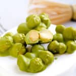 Macadamia nuts dipped in matcha chocolate stacked on top of each other.