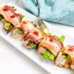 Bacon-wrapped chicken being picked up with a silver fork.