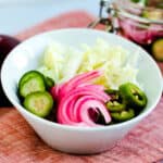 Asian pickled vegetable served in a white bowl.