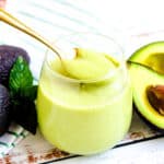 Avocado pudding being scooped out with a golden spoon.