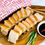 Asian crispy pork belly belly sliced and severed with garlic soy dipping sauce, top down shot.