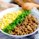 Japanese soboro don ground chicken bowl served in a white with a wooden spoon.