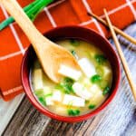 Bowl of tofu miso soup served with tofu and green onions, top down shot.