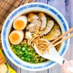 immi ramen served in a ramen bowl topped with Japanese style soft boiled eggs and chashu pork.