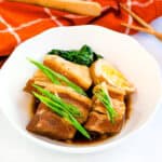 Japanese braised pork belly served in a bowl topped with sliced ginger and green onions.