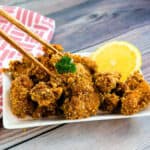 Japanese fried chicken being picked with a pair of chopsticks.