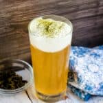 Sea salt foam iced green tea served in a glass tumbler topped with a sprinkle of matcha.