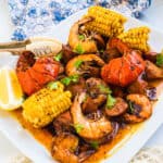 Cajun style lobster boil boiling crab copycat served on a plate with a side of lemon.