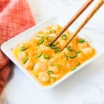 Dynamite shrimp being pick up with a pair of chopsticks.