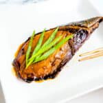 Baked teriyaki yellowtail served on a plate.