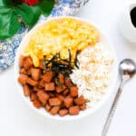 Spam egg rice bowl garnished with shredded seaweed.
