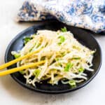 Bean sprouts salad being picked up with chopsticks.