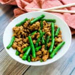 Pork and green bean stir fry served on a plate.