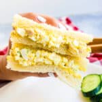 Japanese style egg sandwich being picked up with hands.