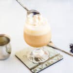 Sea salt cream being spooned on top of milk tea.