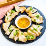 Pork jowl served on a plate with dipping sauce.