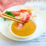 Crab being dipped into garlic miso butter.