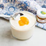 Sweet silken tofu pudding being scooped out with a spoon.